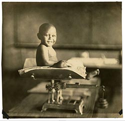 Smiling child on weight scale at Bradley Health Center