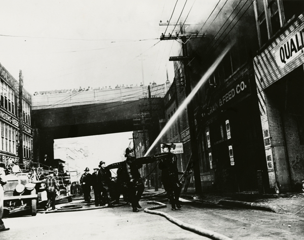 Firemen putting out a fire at 3rd Ave. Grain and Feed Company