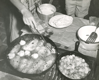 Frying up fish, hush puppies, and potatoes