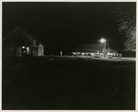 Barnyard illuminated by electric lights